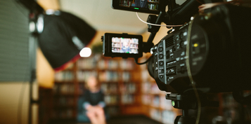 Une caméra filme une personne dans une bibliothèque